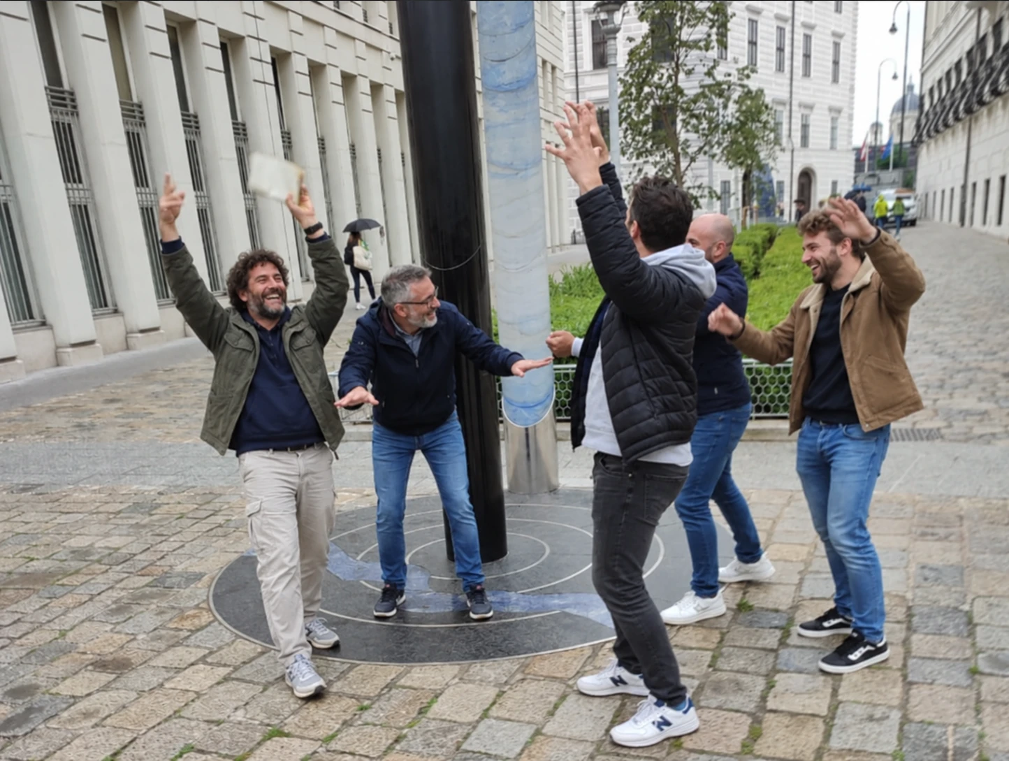 Un groupe de collègues célèbre, bras levés et rires, un défi réussi dans une rue
